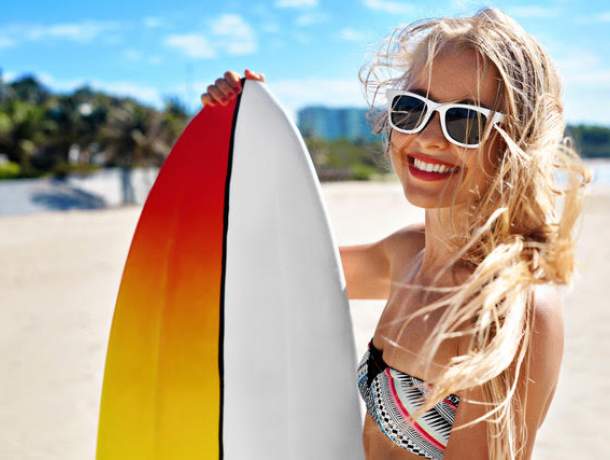 Close up of a young woman holding a surfboard