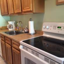 galley style kitchen, oak cabinets, flat top stove, dishwasher, coffee maker