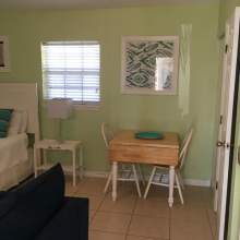Light green walls, two person table, partial images of bed and couch