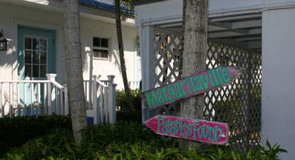 Entryway to Bungalows, palm and directional signs reading Margaritaville and Paradise Found